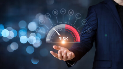 Businessman displaying a digital risk assessment gauge with various icons representing business and financial concepts on a blurred background