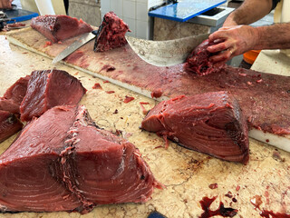 Man cutting fresh fish tuna at market. Close-up. Funchal. Madeira. Portugal.