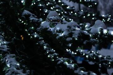 Decorated Christmas tree with Christmas balls, tinsel and warm yellow lights. Festive atmosphere.