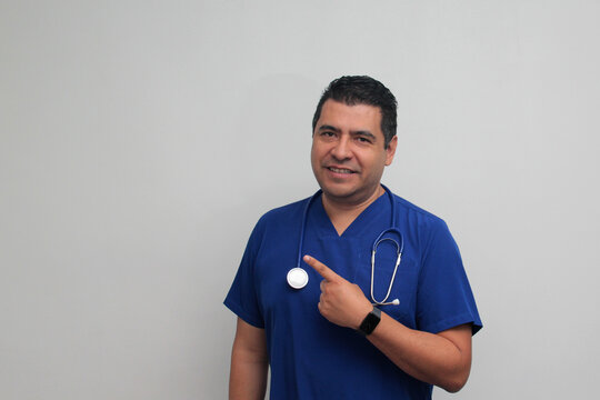 Dark-skinned Latino male specialist doctor with a stethoscope points with his finger with an expression of joy and surprise