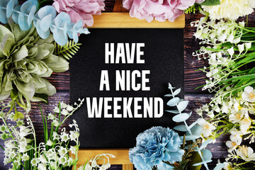 Have a Nice Weekend text with flowers bouquet decoration on wooden background