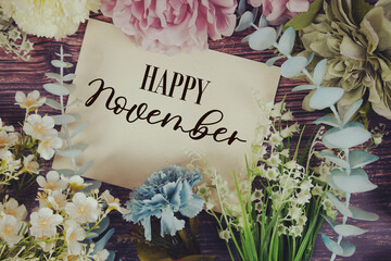 Happy November text with flowers bouquet decoration on wooden background