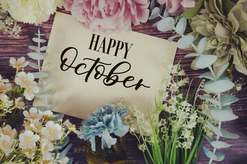 Happy October text with flowers bouquet decoration on wooden background