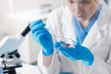 Scientist working with sample in Petri dish in laboratory, selective focus