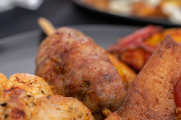 Plate of food with a skewer of meat and a piece of bread. Scene is casual and relaxed, as it is a...