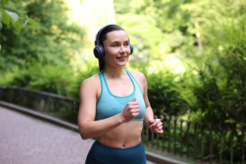 Sporty woman with headphones running in park