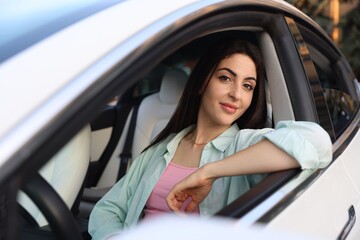 Woman sitting in modern car, view from outside
