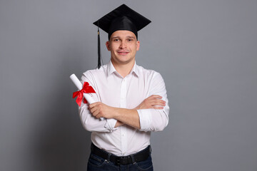 Happy student with diploma after graduation on grey background