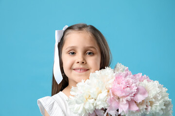 Cute little girl with bouquet of beautiful peonies on light blue background