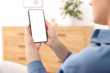 Woman using modern smartphone at home, closeup