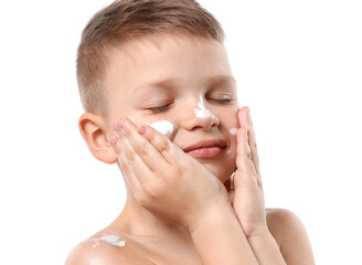 Little boy applying sun protection cream onto his skin on white background