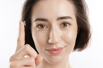 Woman with contact lens on white background, closeup
