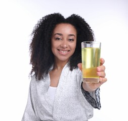 Beautiful Brazilian woman with glass of collagen water on white background, selective focus