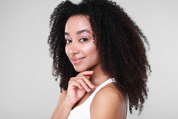 Beautiful Brazilian woman with healthy skin on gray background