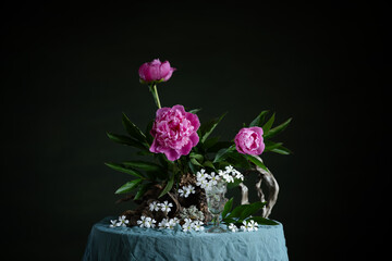 Graceful peonies, radiating elegance and tenderness, with branches and snags. A harmonious...