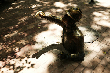 Playful bronze statue of a worker emerging from a manhole in Subotica, Serbia. The quirky public...
