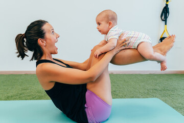 Mother doing fitness exercises with her baby at home