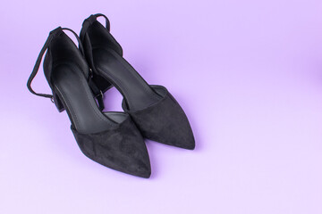 Elegant Black High Heels on Purple Background: Modern Fashion Footwear Design