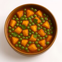 A bowl of traditional Indian Aloo Matar curry placed on a clean white background. The dish features golden potato cubes and bright green peas cooked in a rich, spiced tomato gravy, garnished with fres