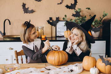 Mother and daughter carving a pumpkin for Halloween