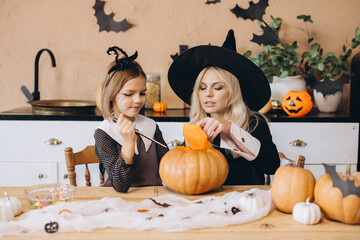 Mother and daughter carving pumpkin for Halloween party