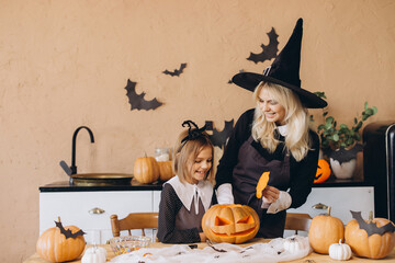Mother and daughter carving pumpkins for Halloween party