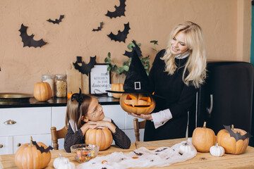Mother and daughter preparing carved pumpkins for Halloween party