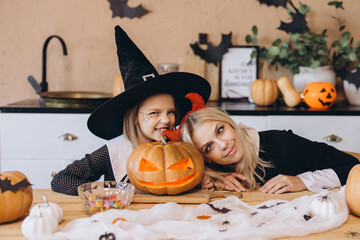 Mother and daughter preparing carved pumpkin for Halloween party