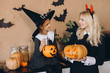 Mother and daughter preparing carved pumpkins for Halloween night