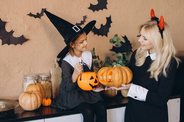 Mother and Daughter Carving Pumpkins for Halloween Party