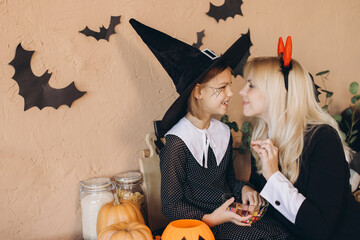 Mother and daughter wearing costumes preparing for Halloween party