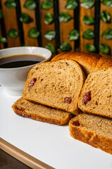 vertical photo of traditional whole wheat artisan sliced bread with guava jam next to a cup of coffee in a healthy vegetarian restaurant in Colombia