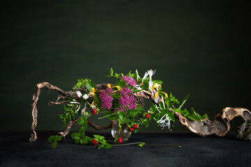 A floral arrangement with pale pink spirea, cinquefoil, and fragrant honeysuckle accented with...