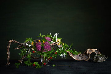 A floral arrangement with pale pink spirea, cinquefoil, and fragrant honeysuckle accented with...