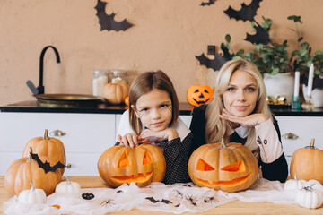 Mother and daughter carving pumpkins for Halloween party