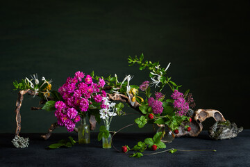 A floral arrangement with pale pink spirea, cinquefoil, and fragrant honeysuckle accented with...
