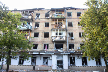 Apartment building with blown-out windows and debris