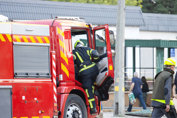 Firefighter climbs into red emergency truck