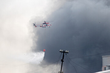 Firefighting helicopter above rooftops during blaze