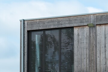 Modern wooden building exterior with venetian blinds and led light