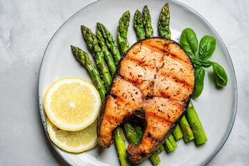 Grilled salmon fish steak over grilled asparagus