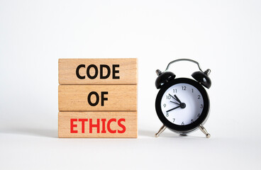 Code of ethics symbol. Concept words Code of ethics on wooden blocks with alarm clock. Beautiful...