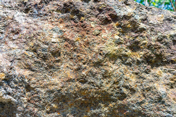 A close-up background of natural stone reveals striking red and yellow mineral veins running...
