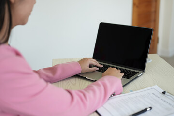 Real estate gent asian woman is reading and checking paper documents, signing the contract to send...