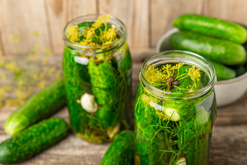 Freshly-salted homemade cucumbers in a jar on a wooden background. pickled cucumbers with dill,garlic and pepper.canned cucumbers.cucumbers and dill.Recipe of homemade preservations.fermented veggies.