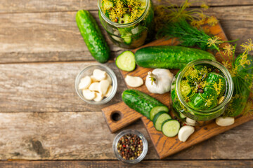 Freshly-salted homemade cucumbers in a jar on a wooden background. pickled cucumbers with dill,garlic and pepper.canned cucumbers.cucumbers and dill.Recipe of homemade preservations.fermented veggies.
