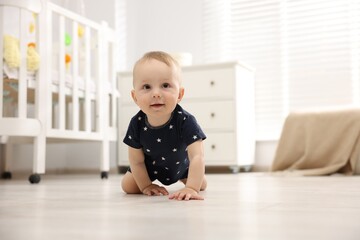 Cute little baby crawling on floor at home