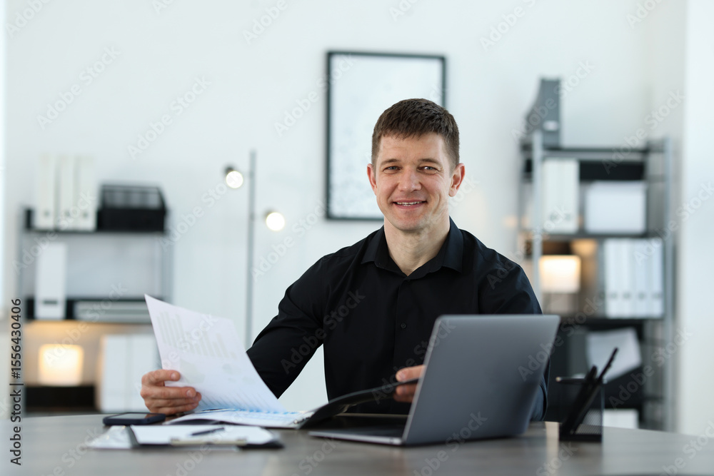 Poster handsome man working with documents at desk in office. space for text