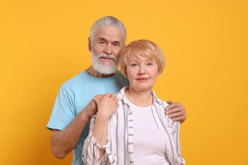 Portrait of lovely senior couple on orange background