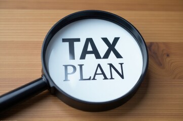 A magnifying glass with the word 'tax plan' written on it, useful for financial and business illustrations..New Year 2026.
